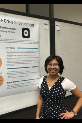 Student posing in front of her poster at a research conference