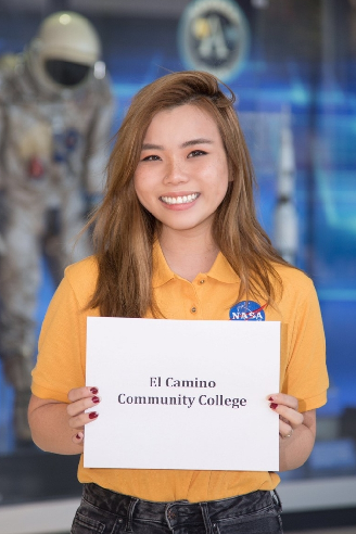 Student wearing a NASA shirt and holding a sign that says El Camino Community College