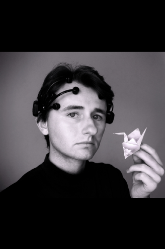 Student wearing an atypical headgear and holding an origami swan