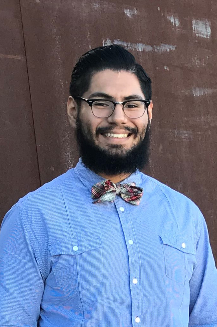 Male student in a blue shirt smiling confidently