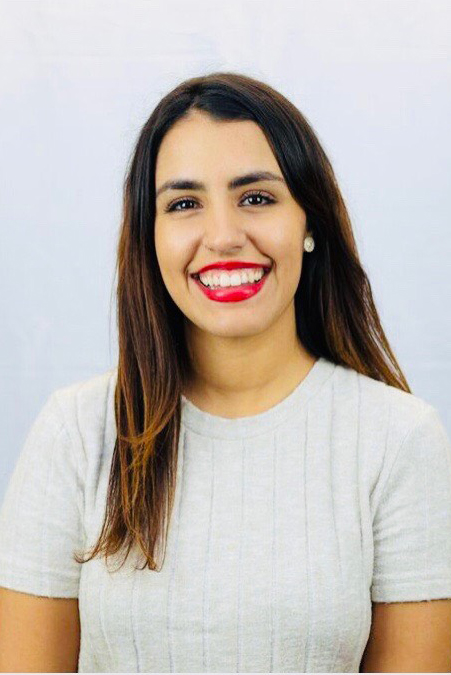 Female student in a white shirt posing confidently