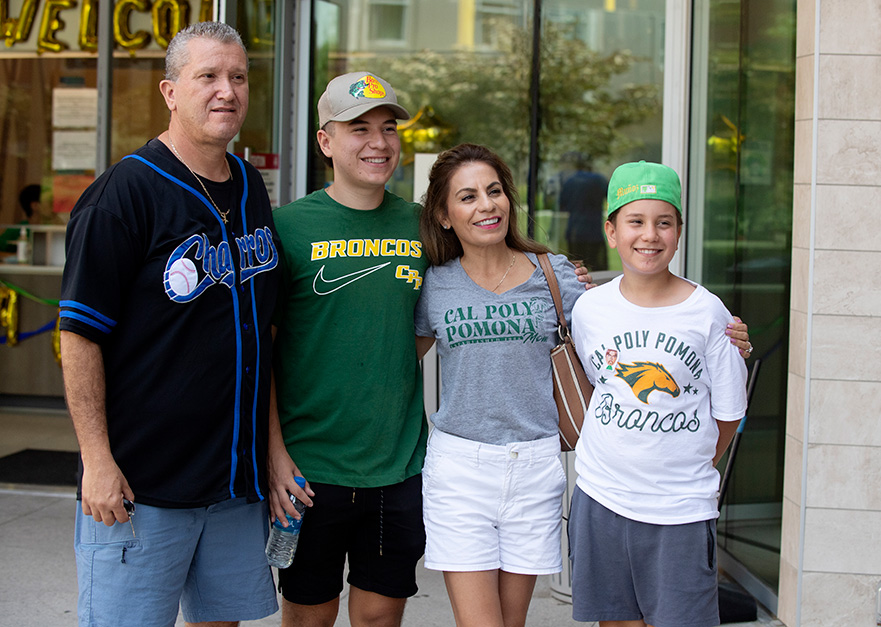 A family poses for a photo at the dorms during Move In Day
