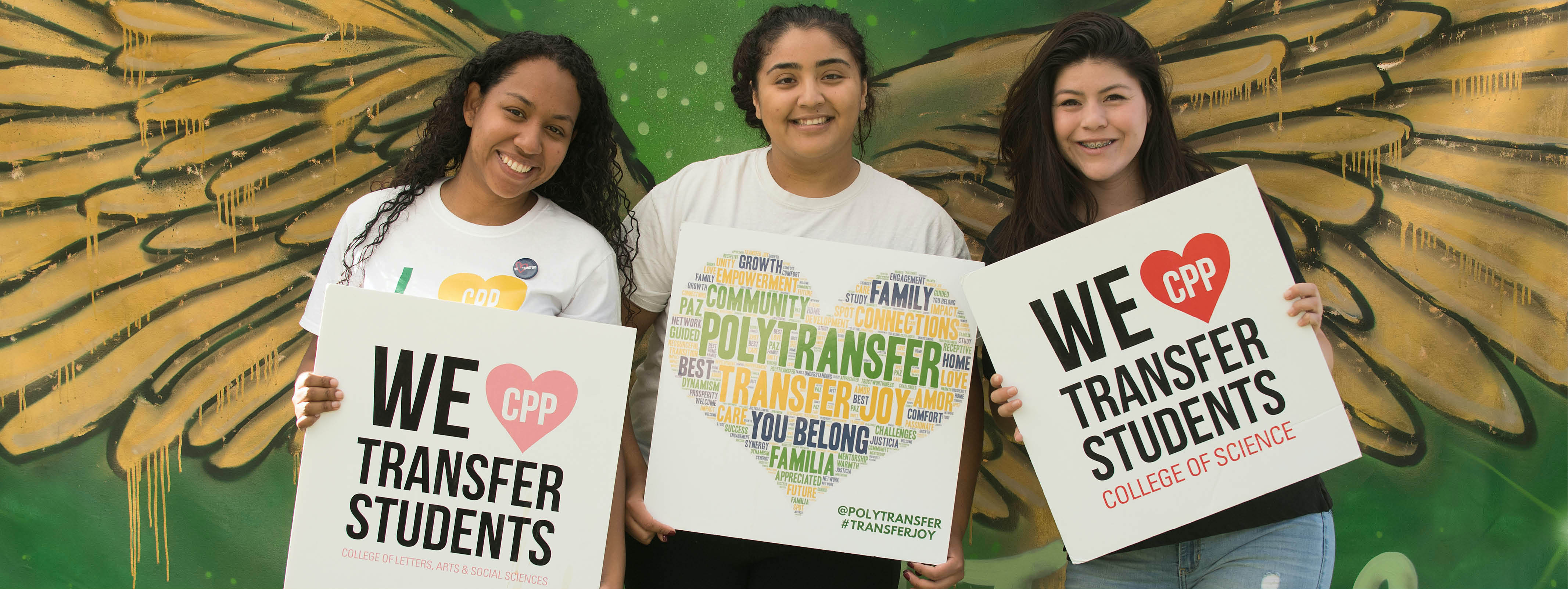 Three female students stand together holding PolyTransfer sign.