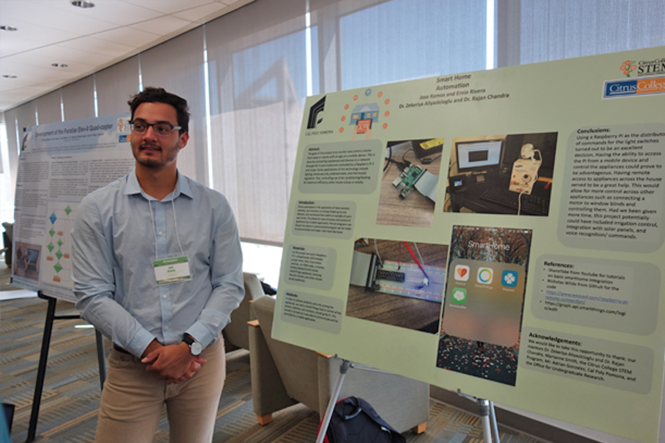 Student posing in front of poster presentation at research conference