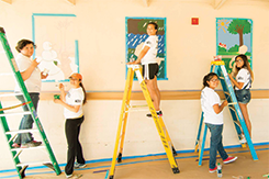 Several students painting a mural
