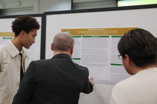 FYE student sharing his poster with CPP faculty at the PolyX FYE Showcase.