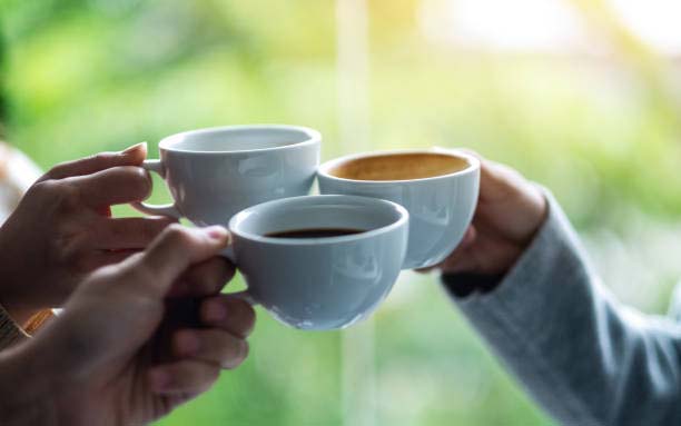 three mugs of coffee being cheered