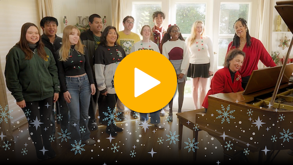 President Levine playing piano while the CPP Choir sings behind her