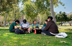 students sitting on a field talking