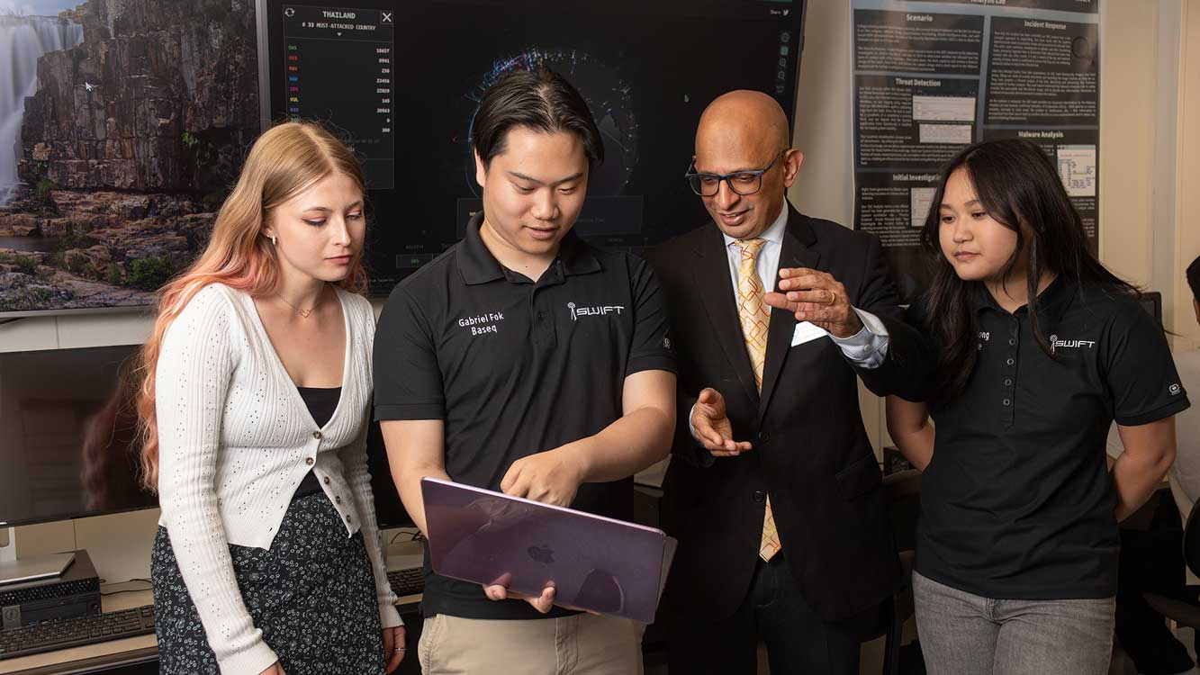 Dean Krishnamirthy in cyber lab with students