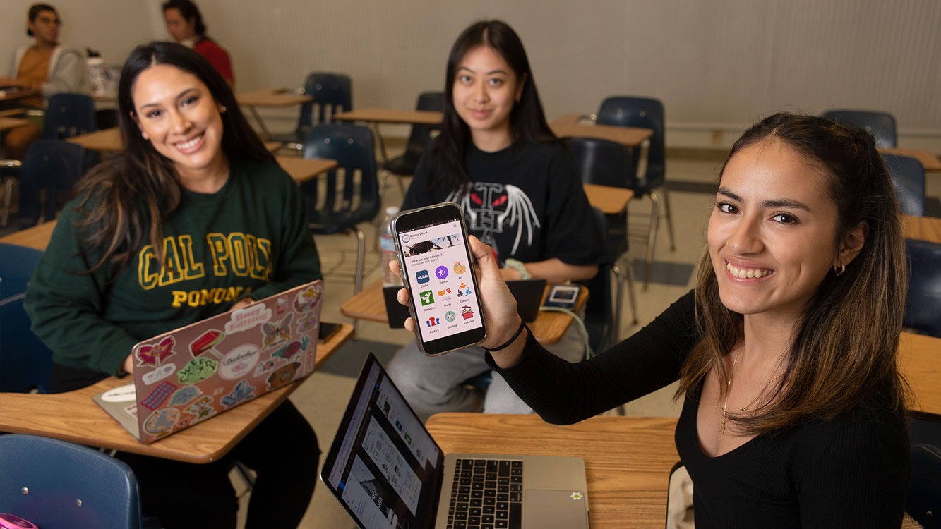 Students showing home page of app screen in marketing class