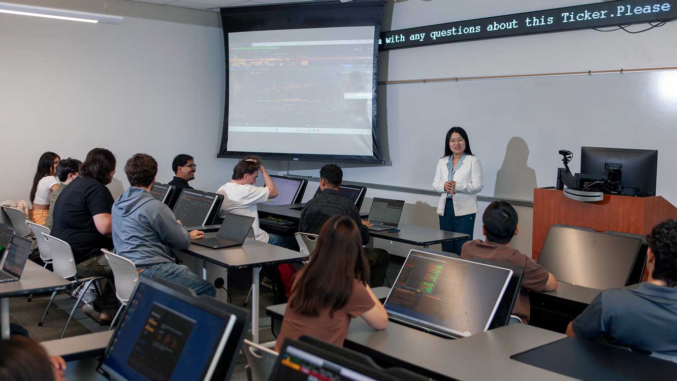 Professor instructing students in Bloomberg lab