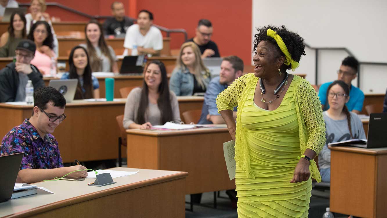 First day of marketing class with professor smiling in front of laughing students