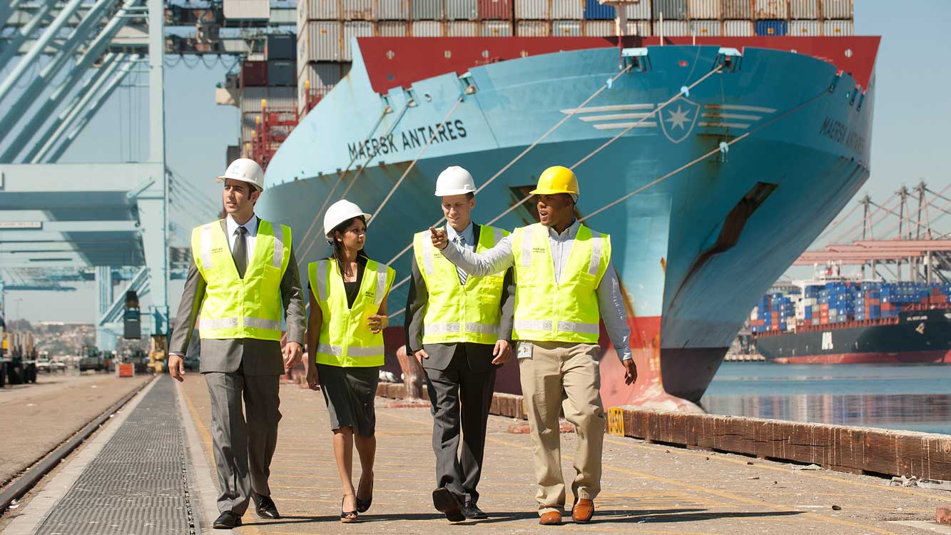 TOM students walking on docks in front of container ship at port of los angeles