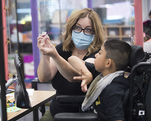 A special education teacher with a student in wheelchair