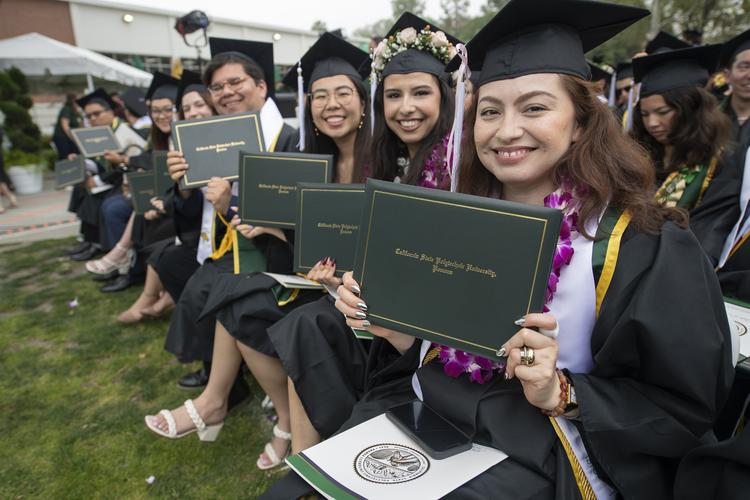 graduates showing their diploma