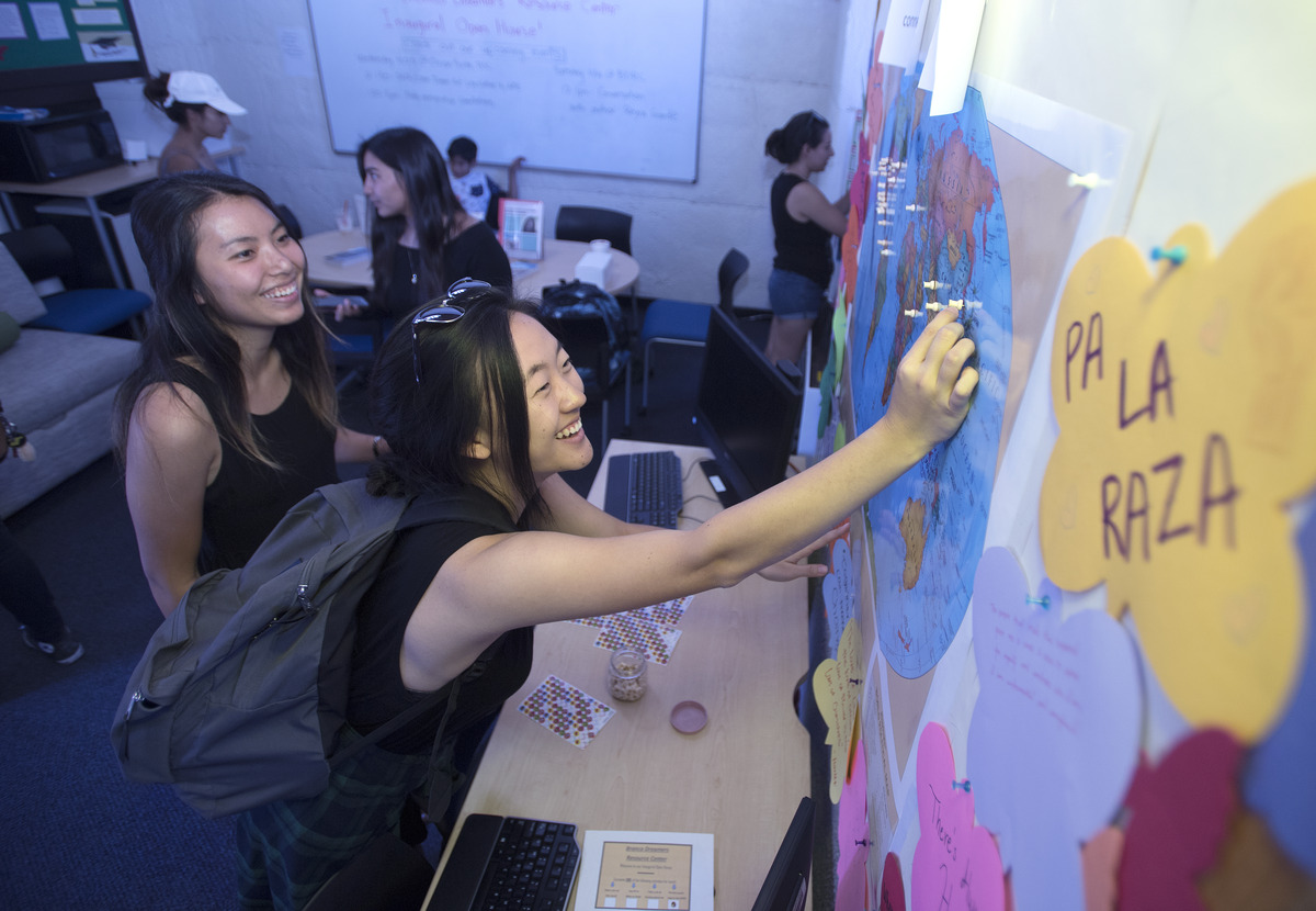 students putting pins on a map