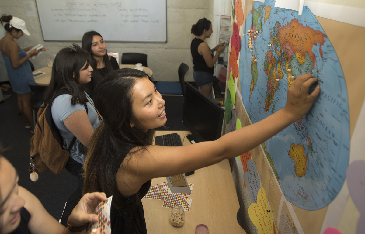 students putting pins on a map