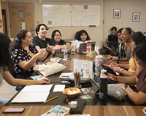 Honor Society students animatedly collaborating around a table