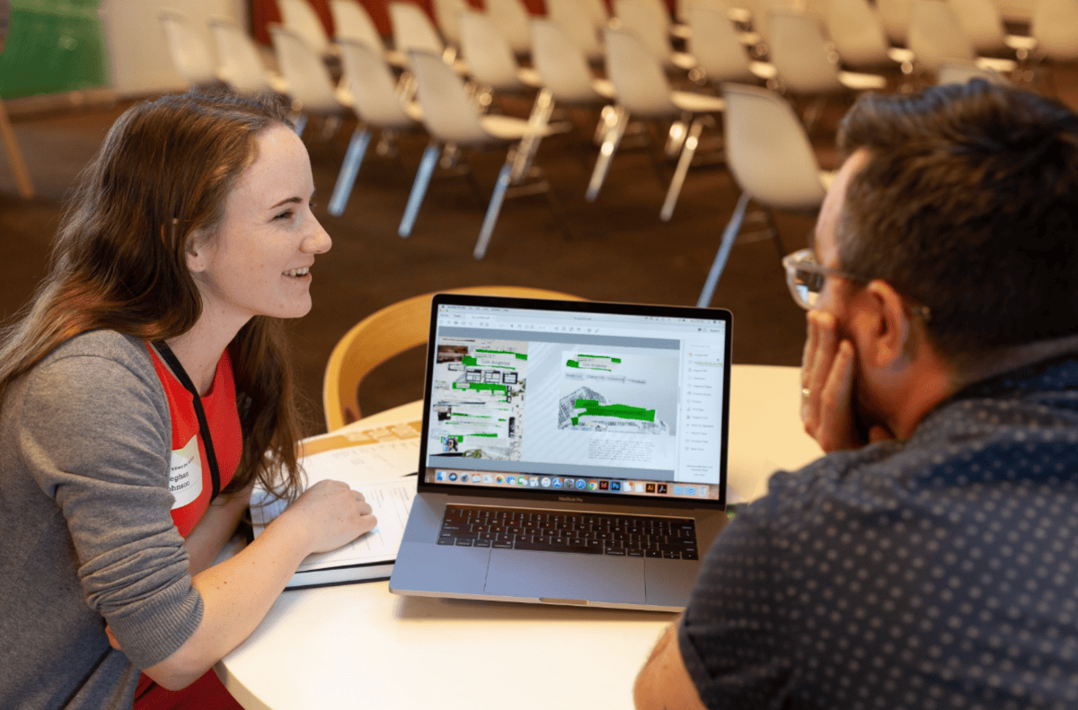 A visual communication design student showing her proposed work to a mentor