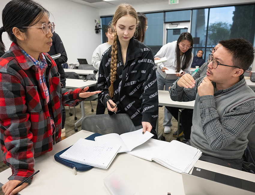 Three students collaborate in ESL class.