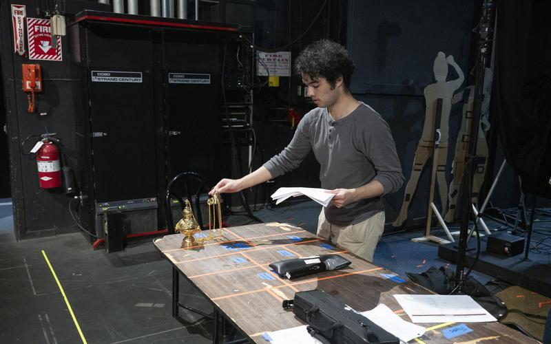 Backstage with student holding a script helping with performance