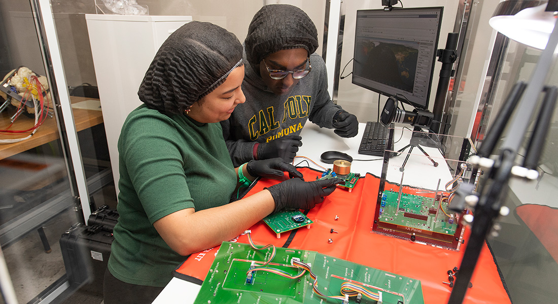 Two female students work on an electrical board