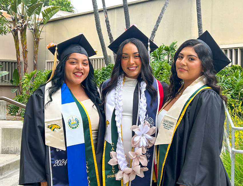 Three female students in commencement regalia
