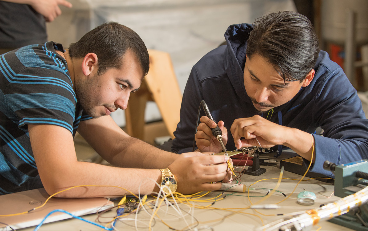 two students working with electronics