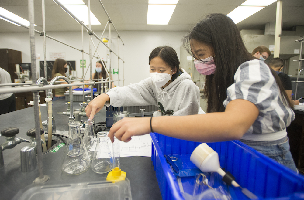 two students look at chemistry equipment