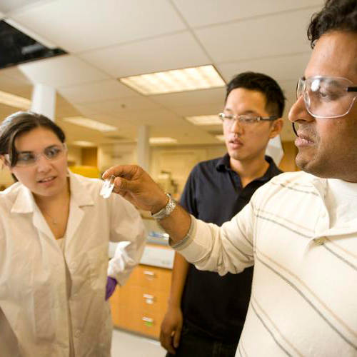 a professor working in the lab with two students