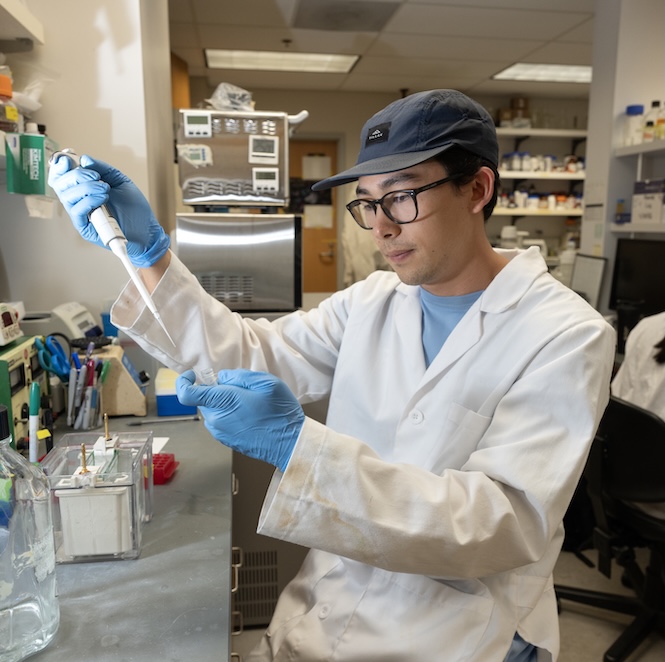 Cooper Bennett measuring a chemical in a test tube in the lab