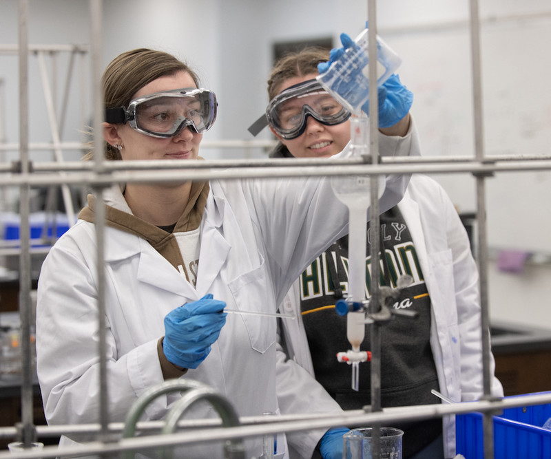 a student pours a chemical for an experiment