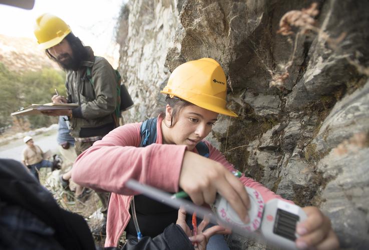 student drilling through a rock