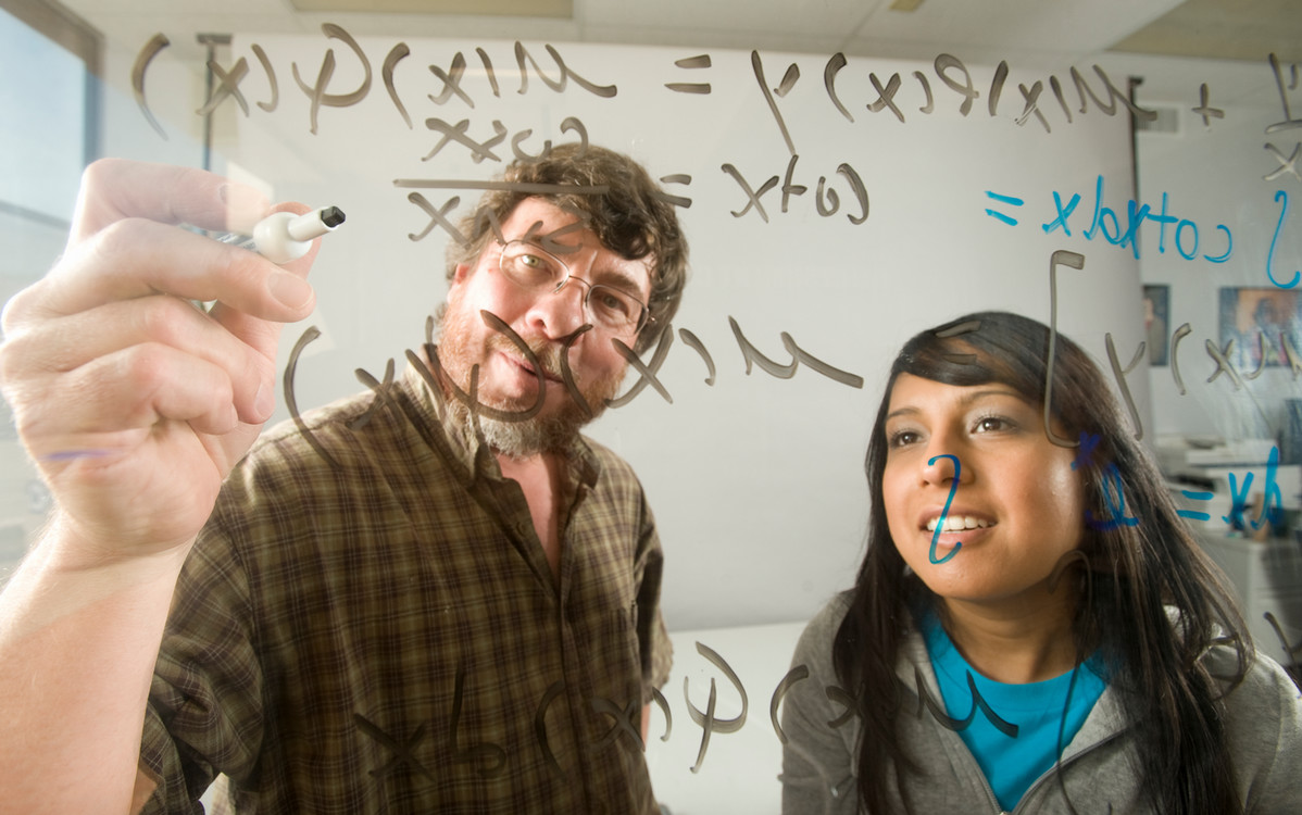 students writing math equations on the board