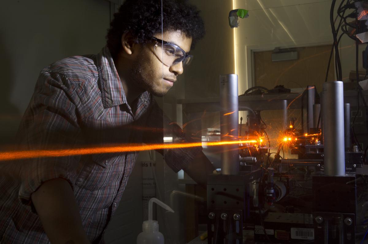 Male student works with a laser.