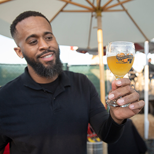 A man holds of a glass of beer at the first preview event