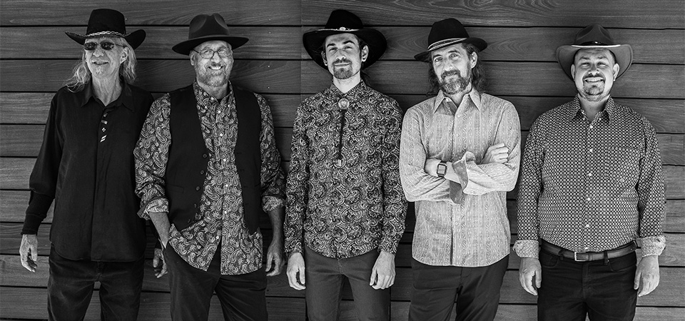 A black and white photo of The Storytellers band members: five men in cowboy hats