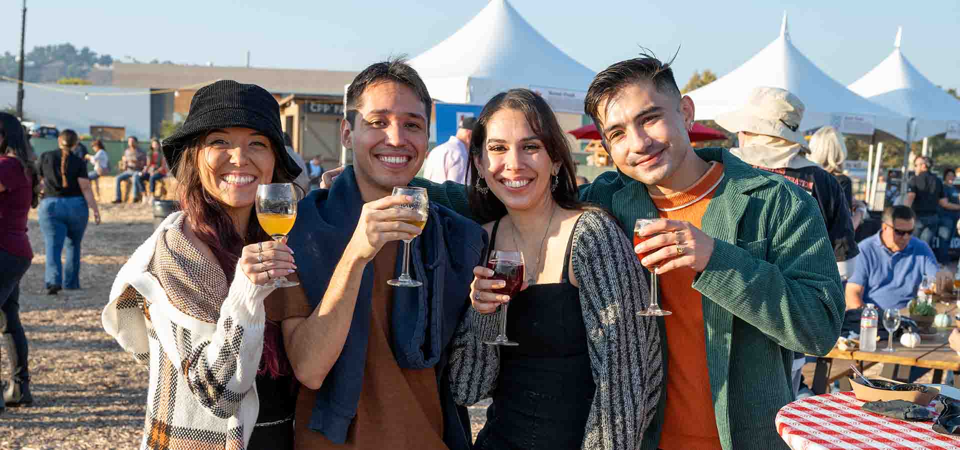 Two men and two women hold up glasses at Preview Night