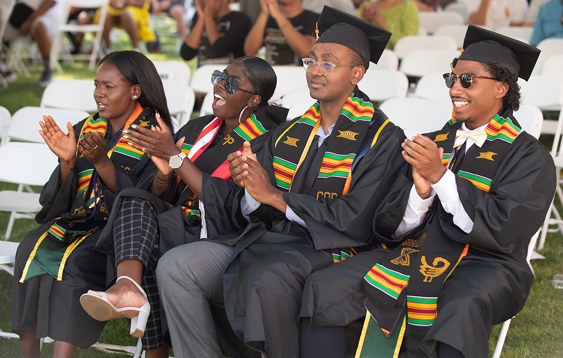 4 black graduates smile and celebrate during the Pan African graduation ceremony