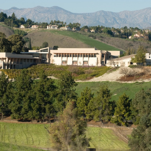 Outdoor view of the collins college surrounded by trees, hills and mountains