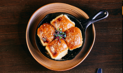 Portuguese Parker House Rolls in a top-down view in a cast iron skillet indoors.