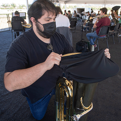 Angel Chacon puts a bell mask on his tuba prior to band practice