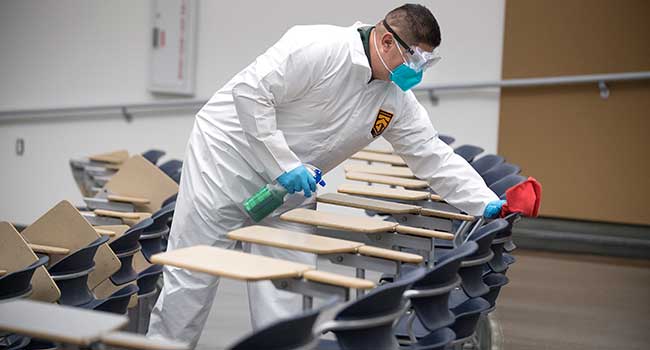 Custodian cleans a room in the University Library.