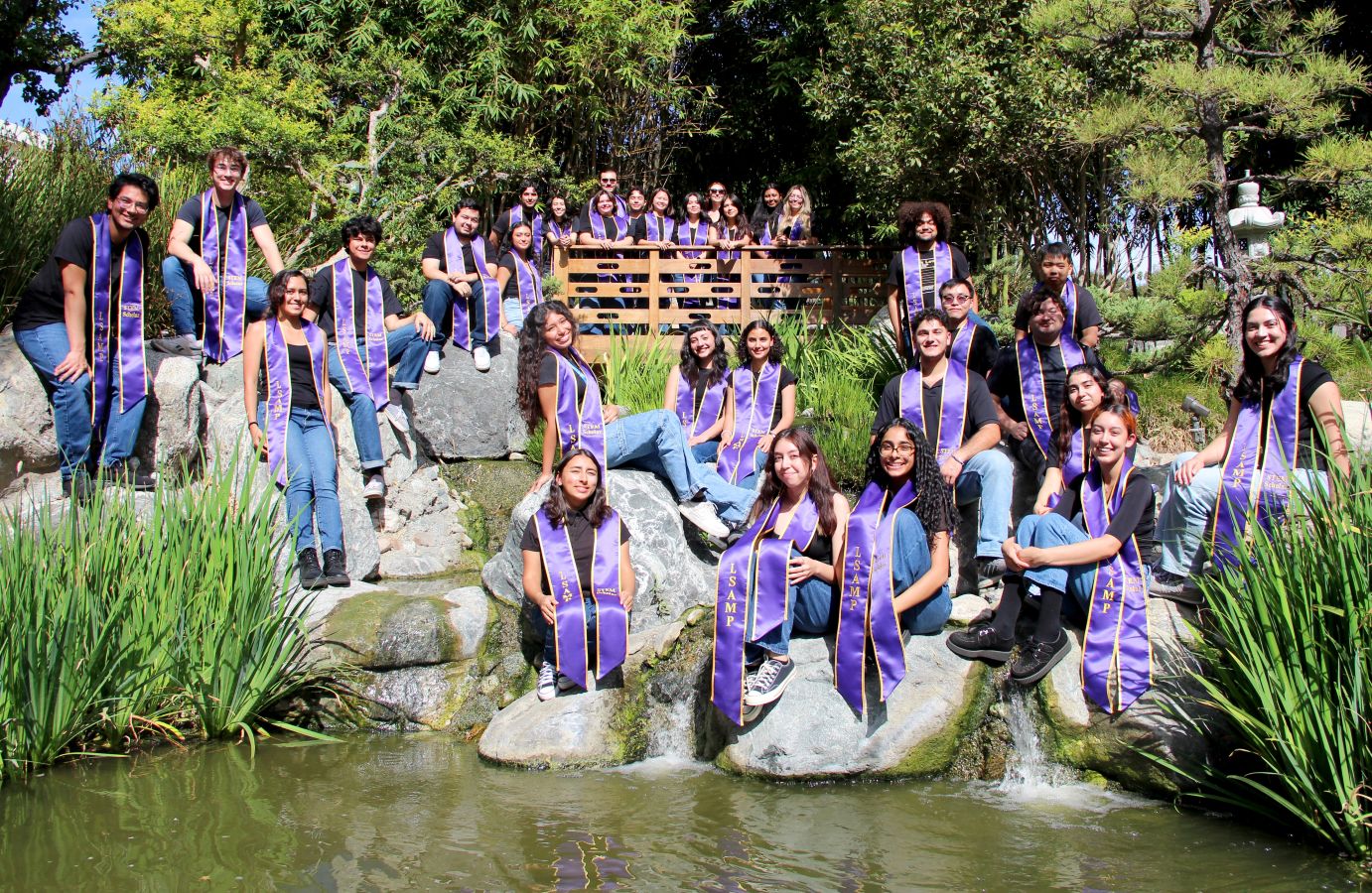 LSAMP Scholars posing on rocks at the edge of a pond