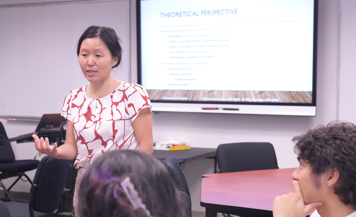 Physics professor Qing Ryan lectures students.