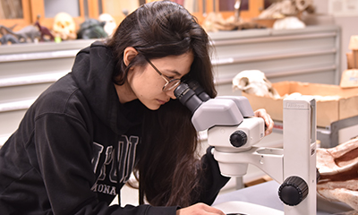 geology student looking through a microscope