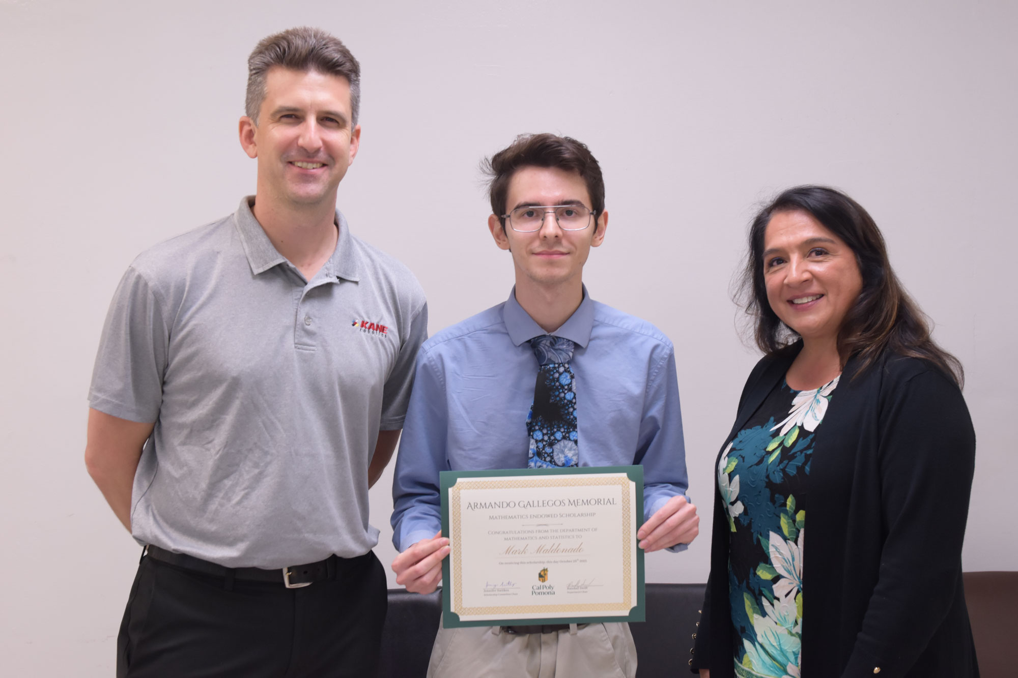 Professor Arlo Caine poses with scholarship recipient Mark Maldonado and representative of the Armando Gallegos Memorial Scholarship.