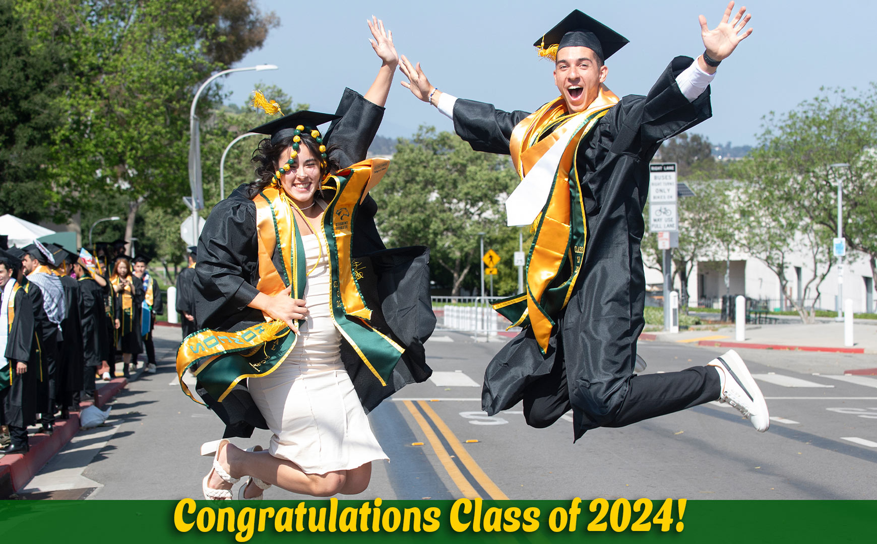 Two 2024 graduates jumping for joy