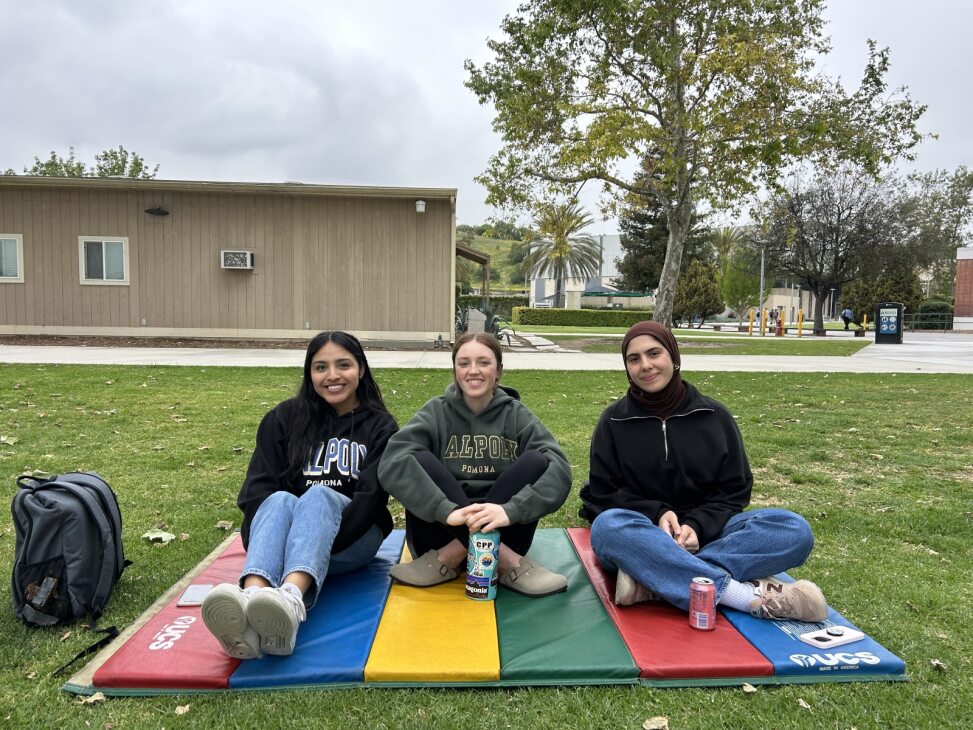Three students sitting on mat